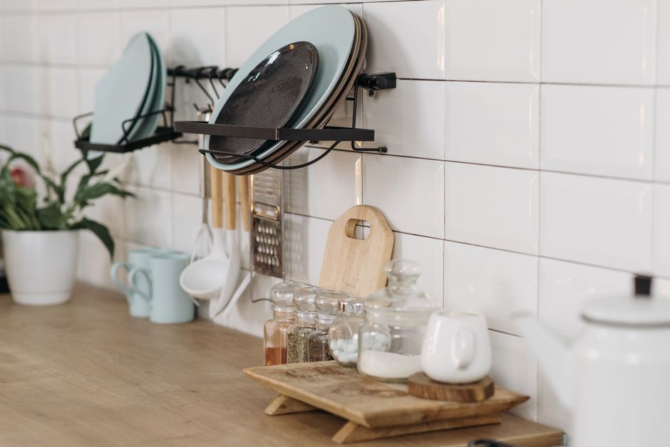 Organized kitchen with utensils, spices, and white tiled wall. Ideal for cooking themes.