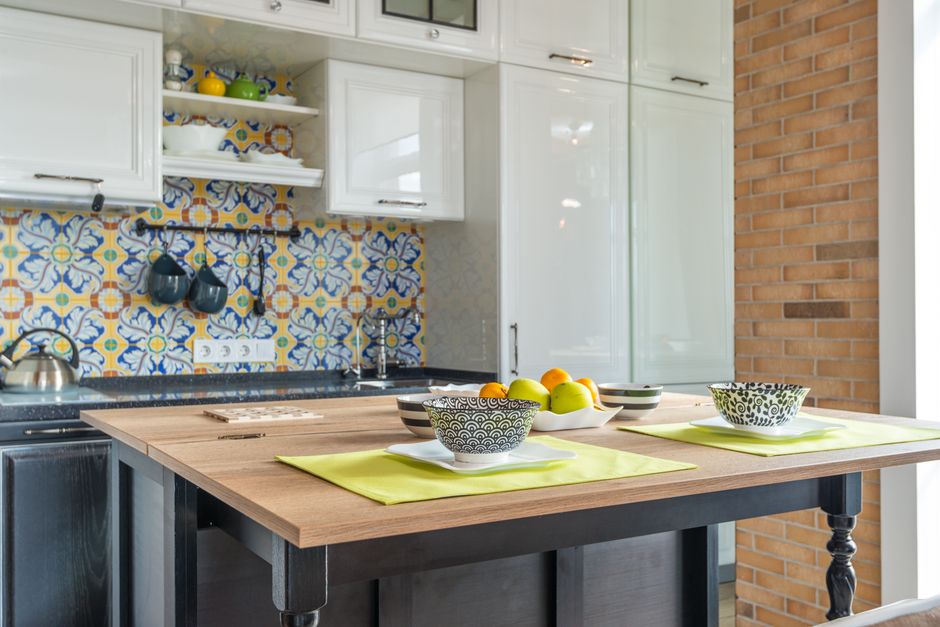 Stylish contemporary kitchen with vibrant printed tiles, wooden tabletop, and elegant interior.